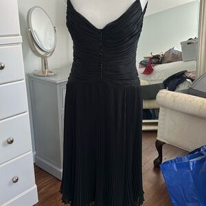 Very elegant black dress with spaghetti straps .

Bottom is pleated and lined